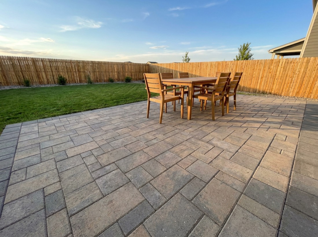 Freshly installed paver patio with outdoor dining set in a Denver backyard