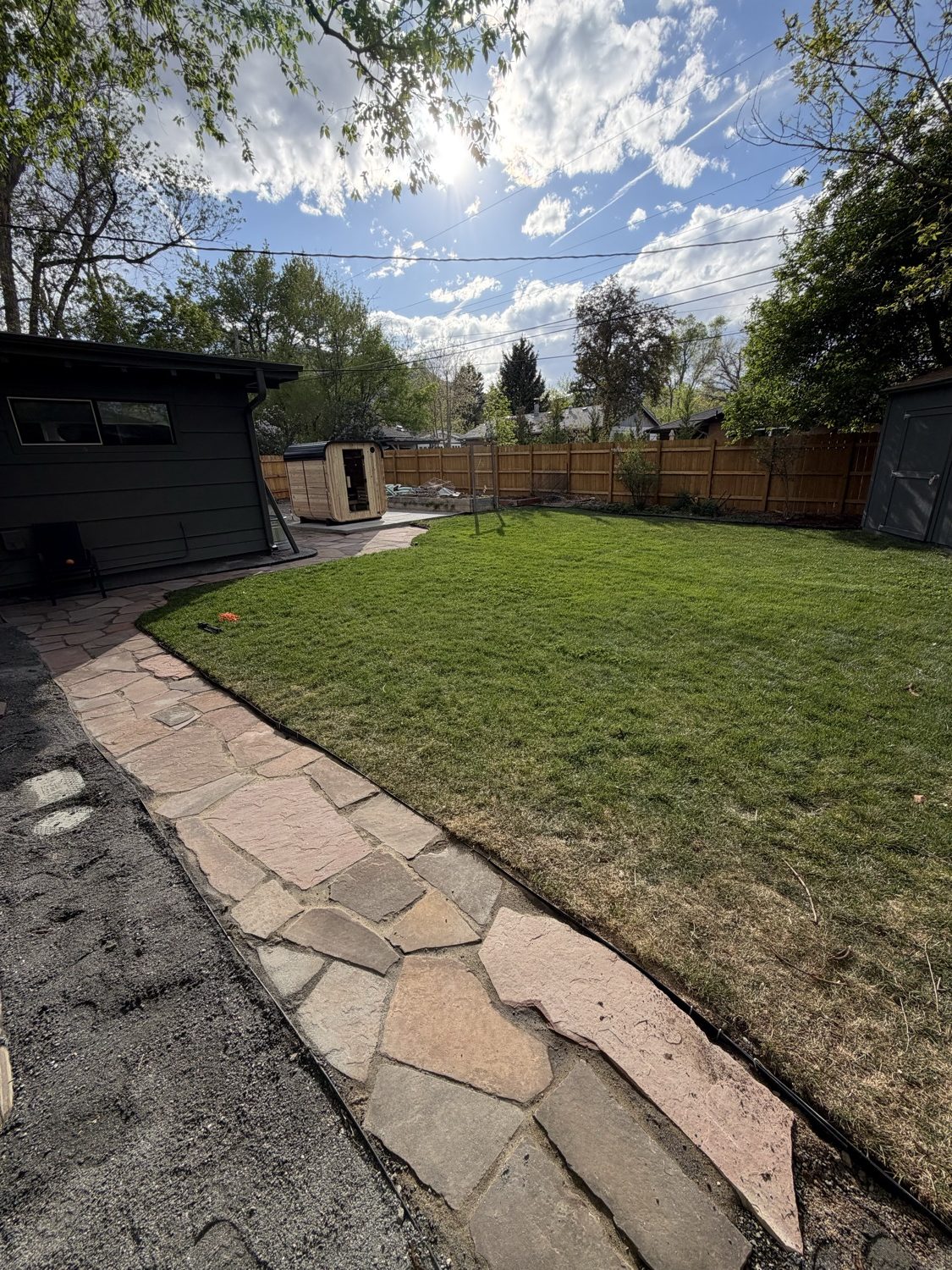 Finished flagstone walkway and lush green lawn built by CJ Landscaping